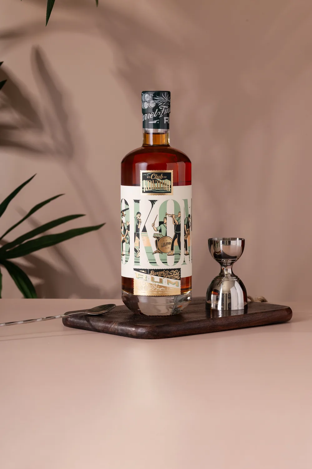 Club Kokomo Barrel Finished rum on a dark tray against a warm pink backdrop
